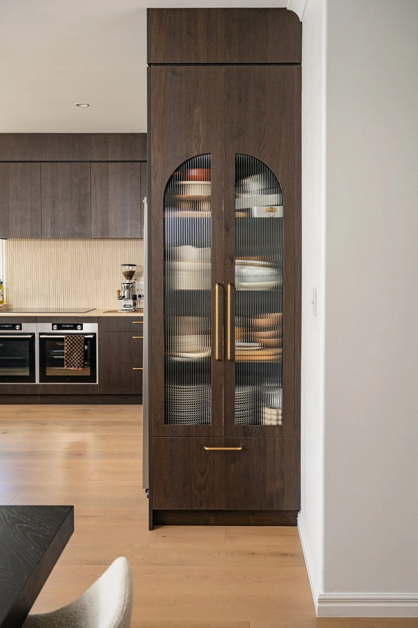 Full-height arched display cabinet with fluted glass and brass handles