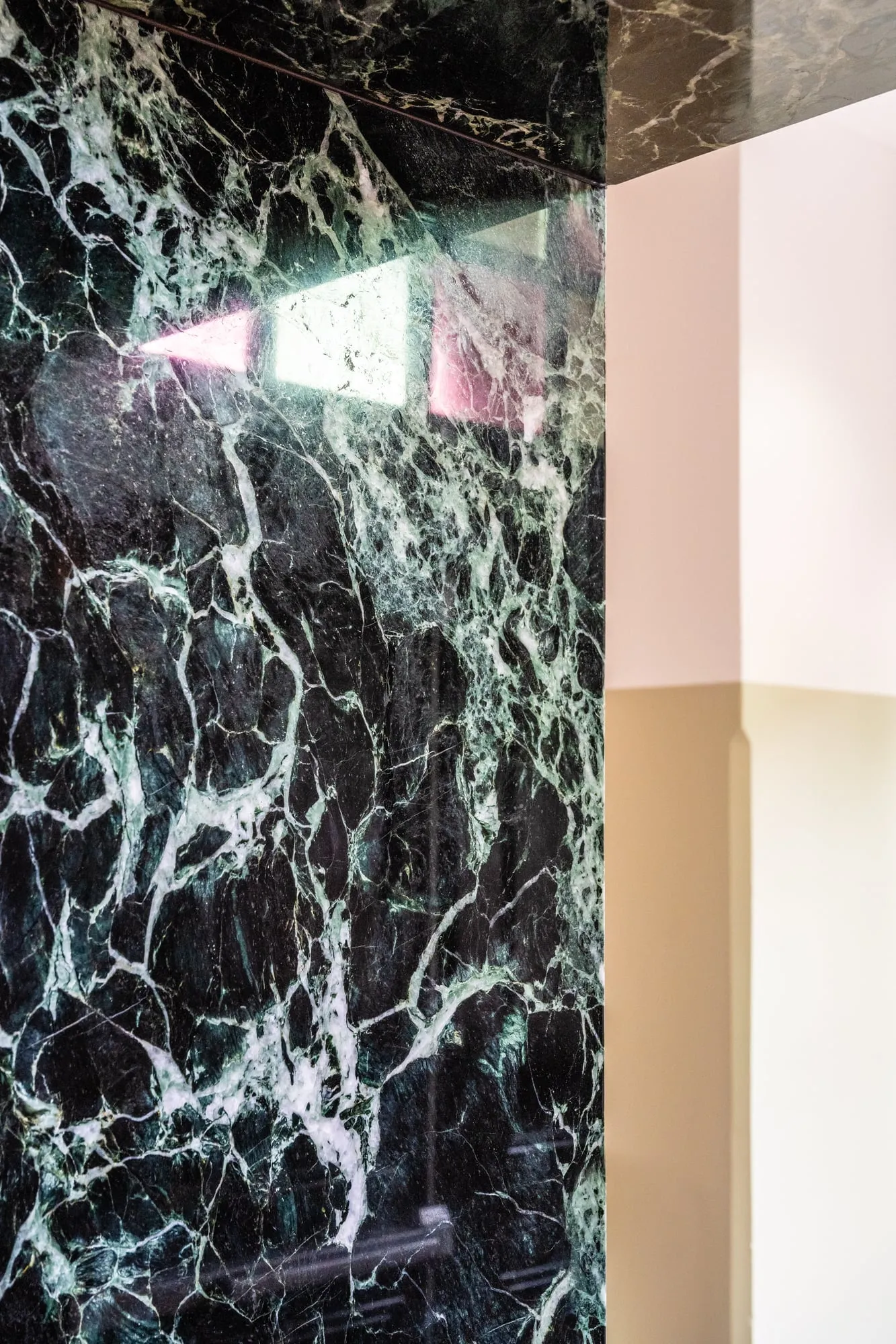 Verde Marble cladding turning a mitred external corner beneath the counter soffit