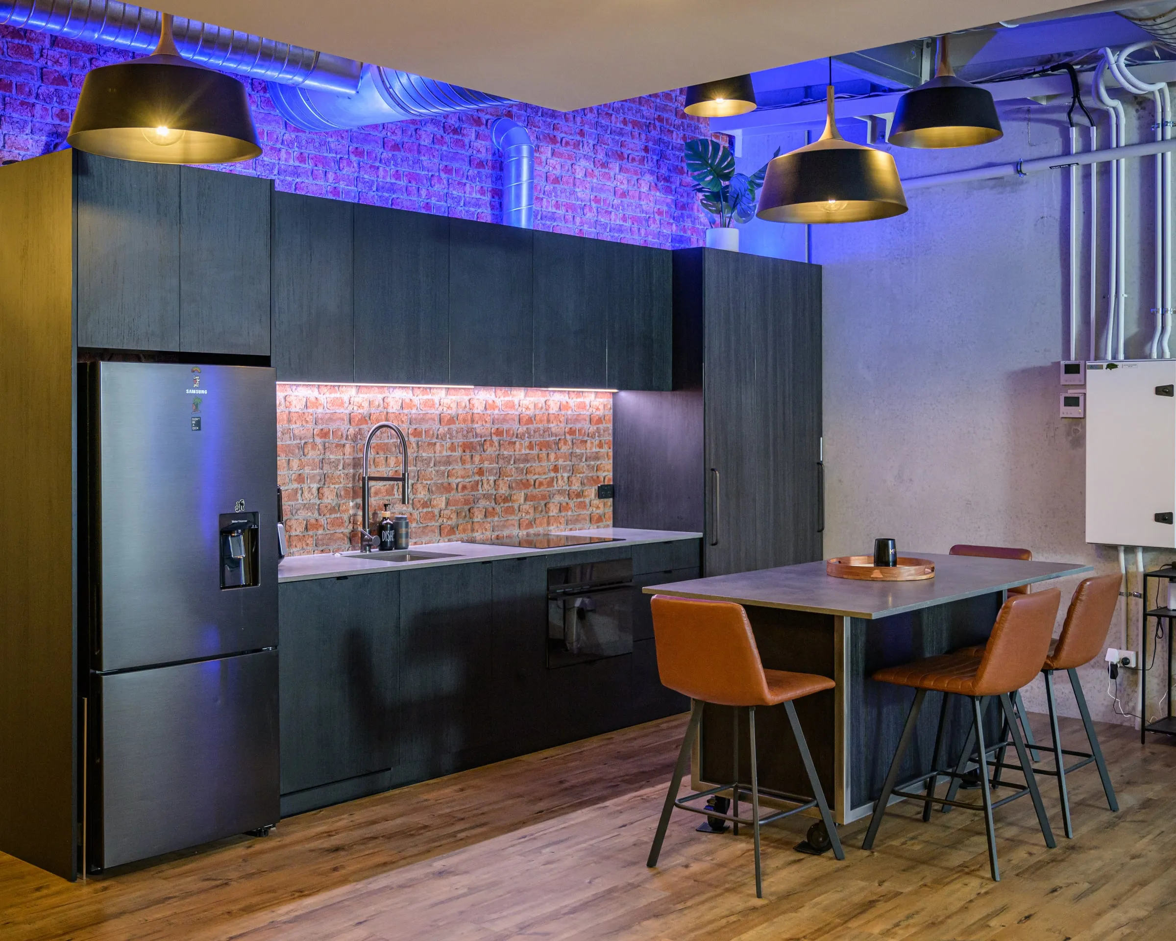 Straight-on elevation of black cabinetry over a recycled brick splashback