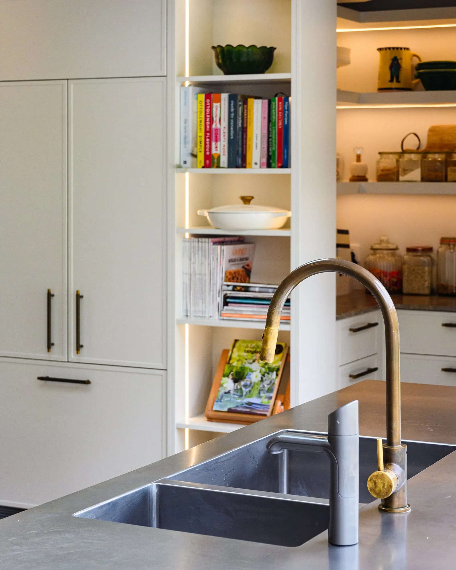 Burnished brass gooseneck tap over the brushed stainless island top