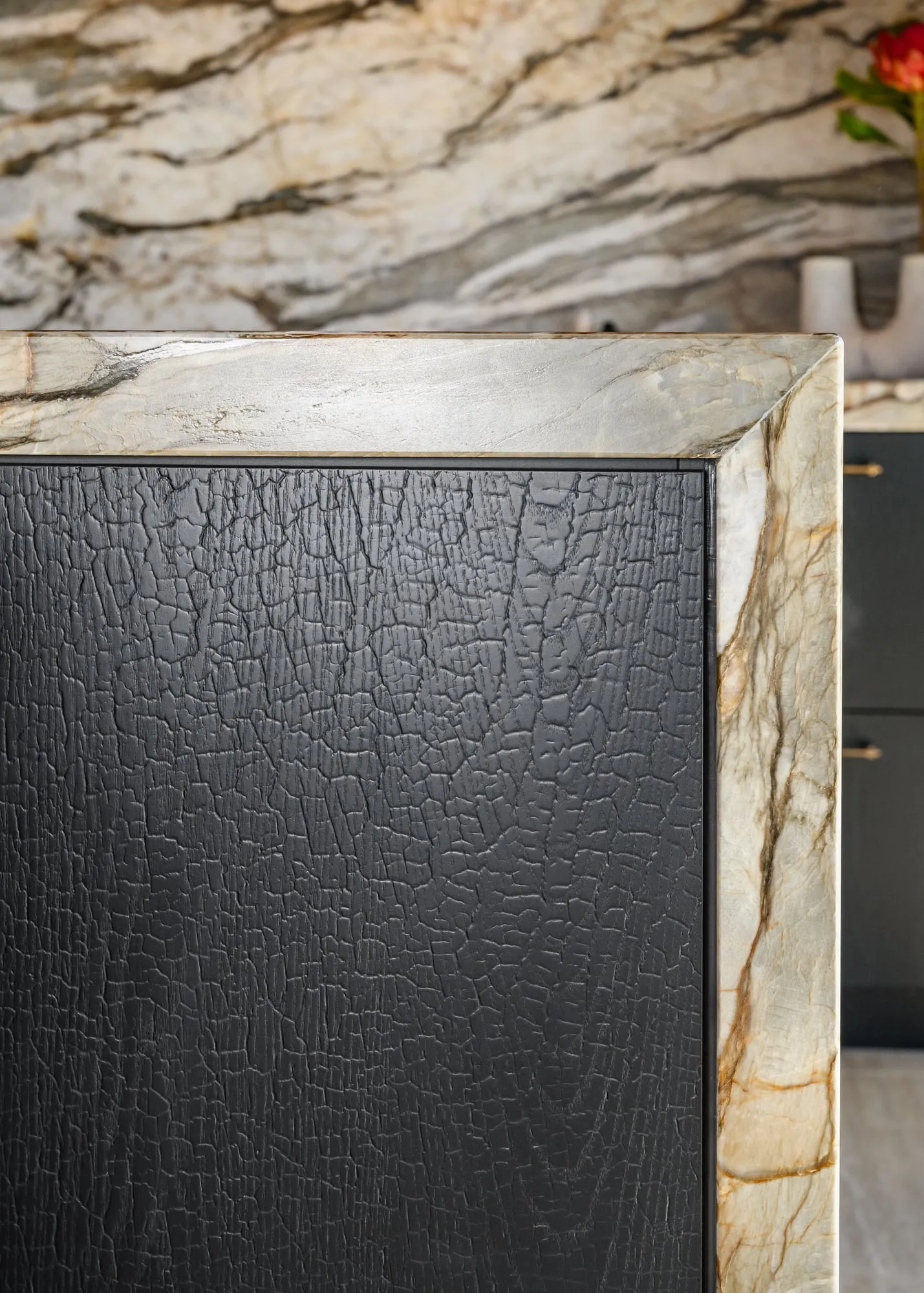 Charred Oak door corner meeting a mitred Quartzite frame
