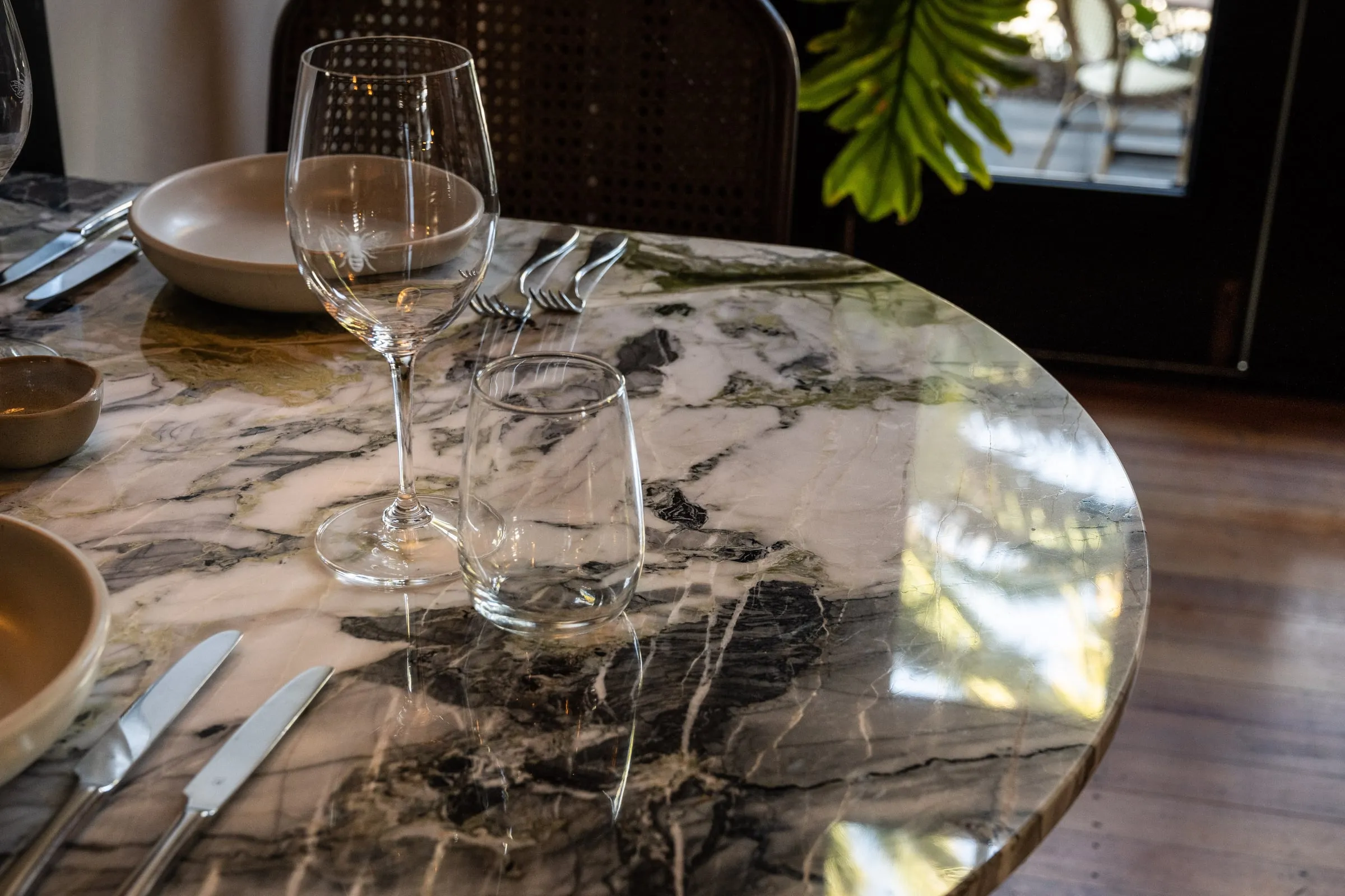 Brass-banded edge of a round green-veined Marble tabletop