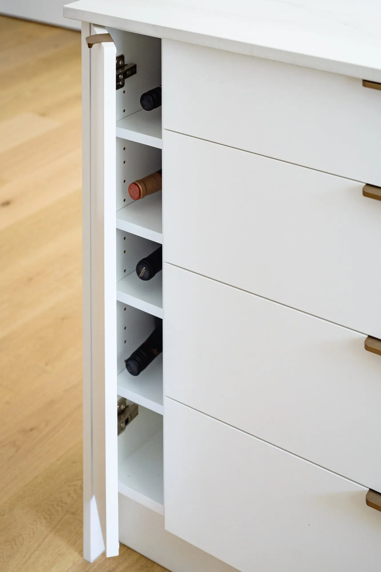Concealed wine store in the island end panel with brass pulls