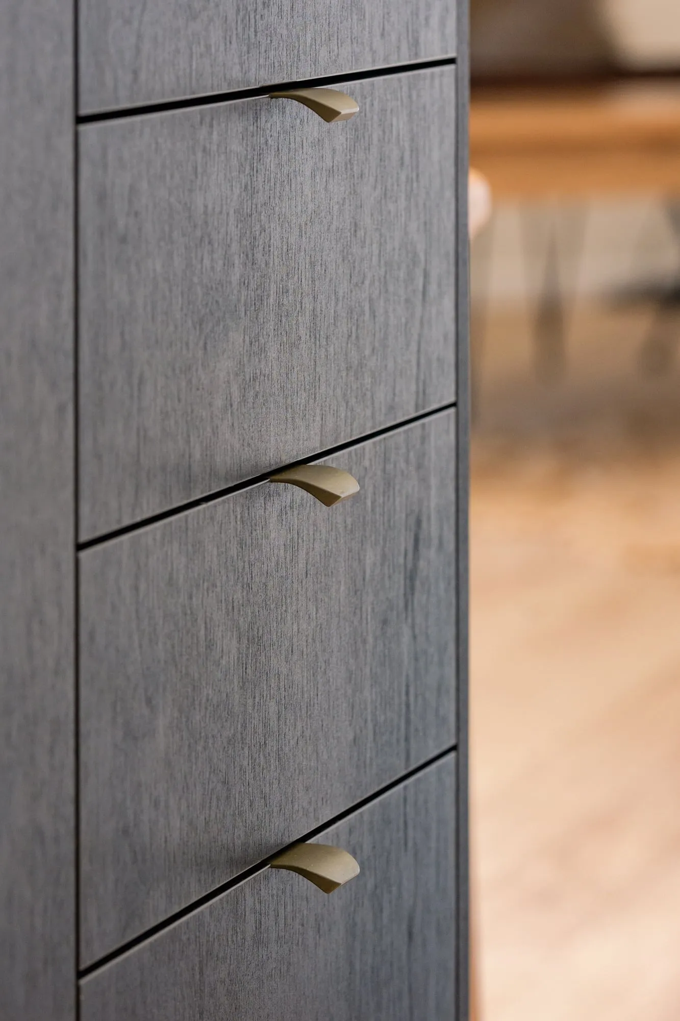 Dark-stained drawer fronts with brass lip pulls and shadow-line gaps