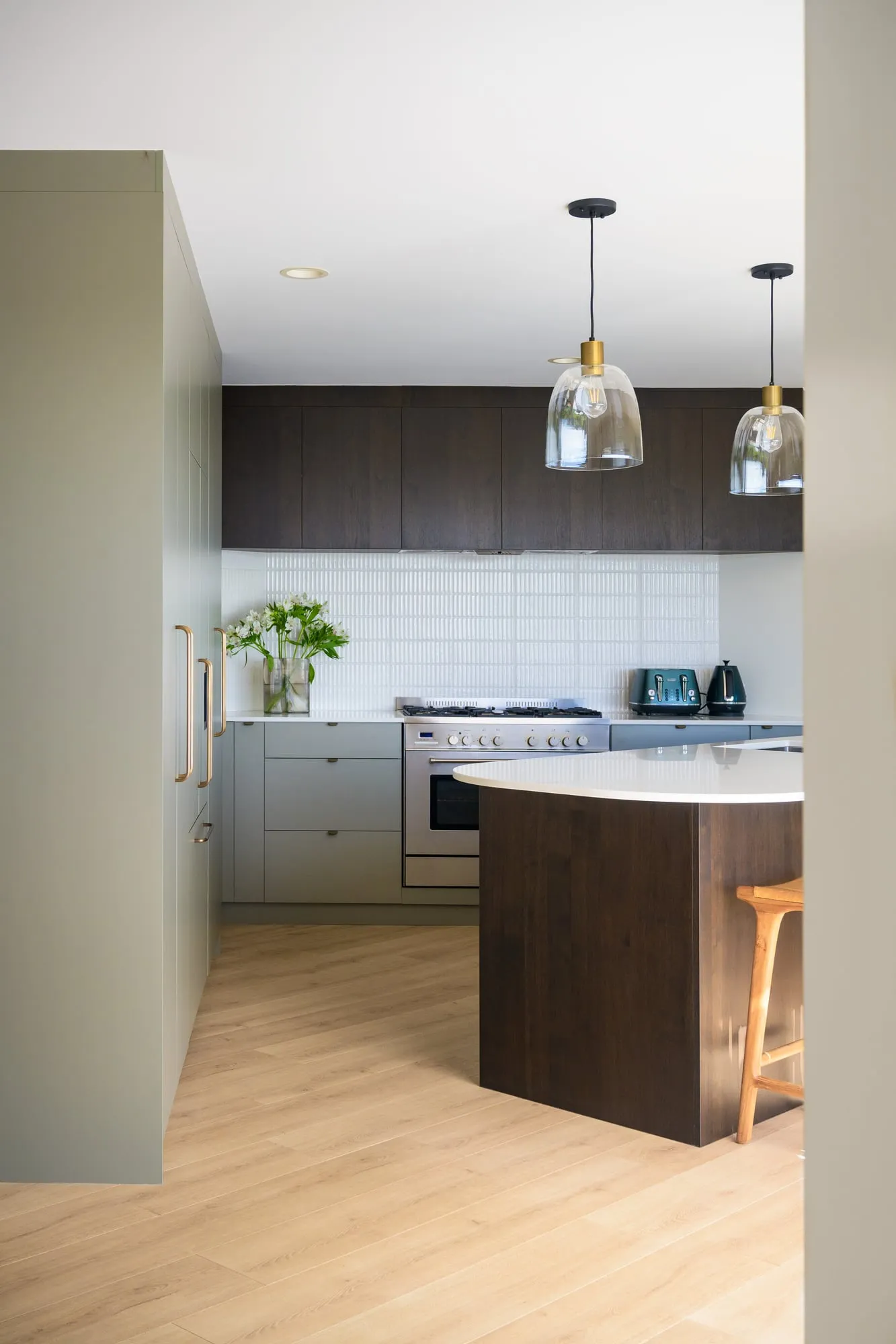 Kitchen elevation with dark-stained uppers, white finger tile and freestanding range