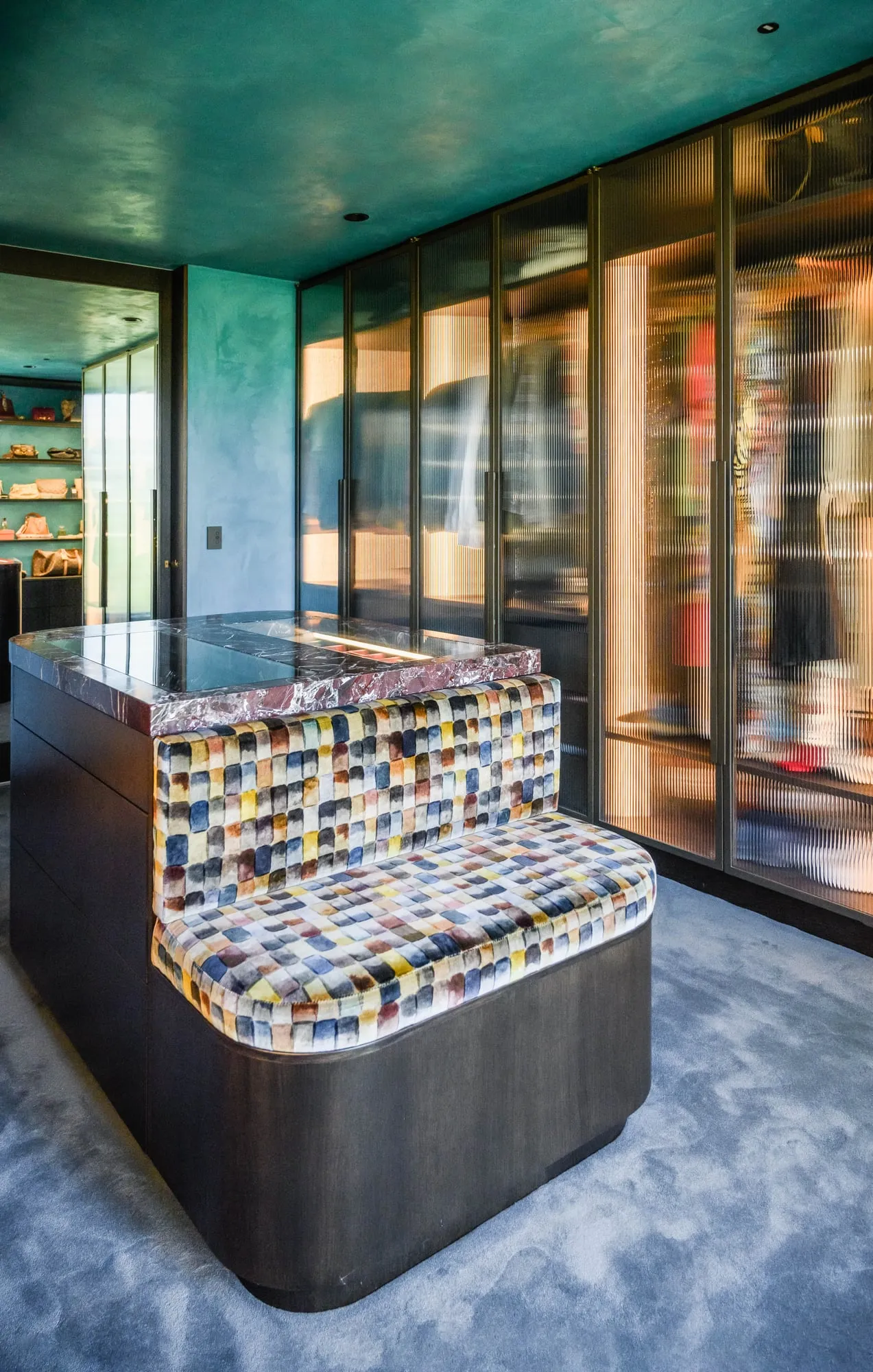 Dressing room with Marble island and bronze fluted-glass wardrobes