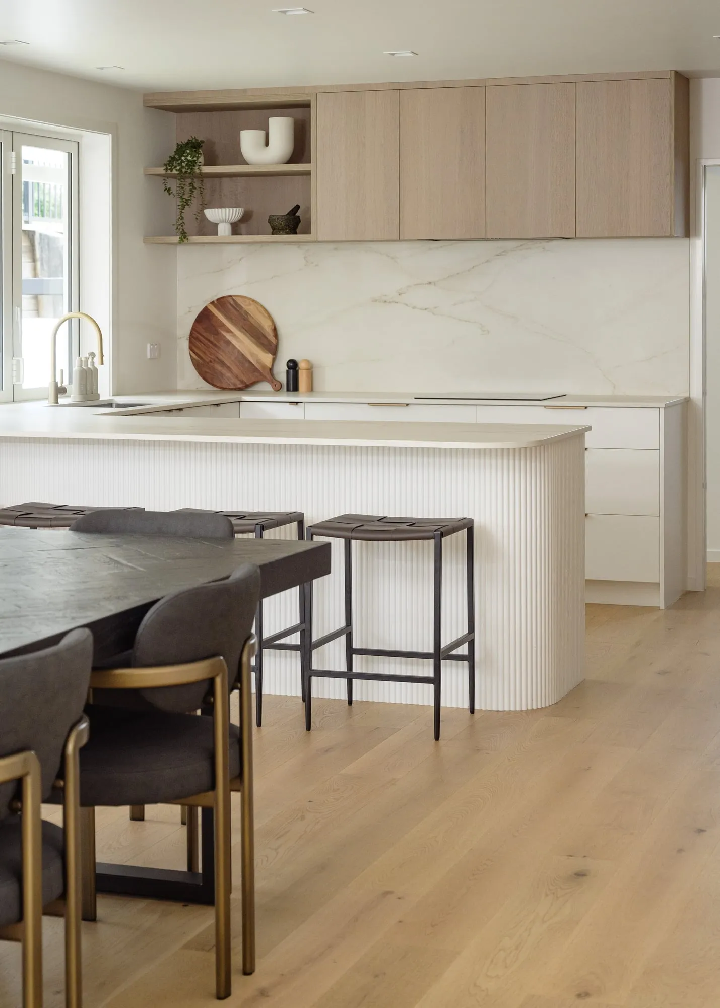 Fluted island with brushed-brass tap and open shelf styling