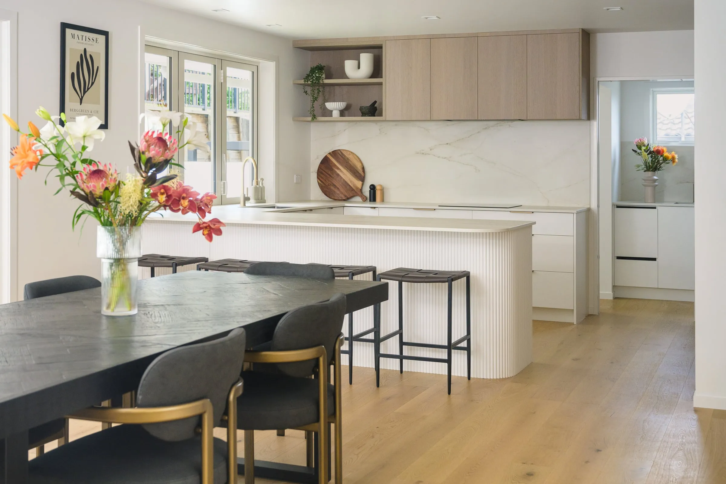 Curved fluted white island in a limed Oak kitchen filled with daylight