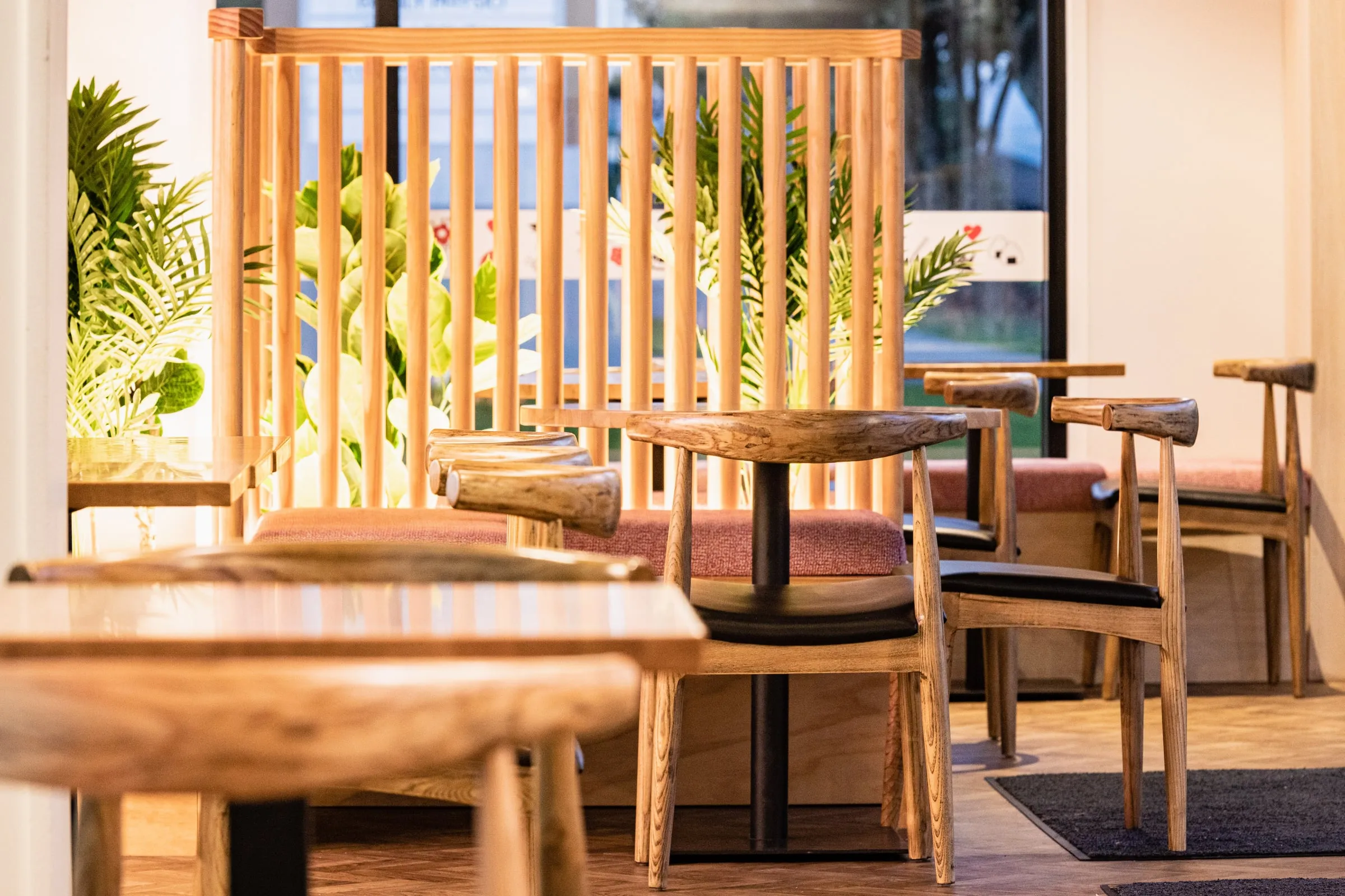 Elm chairs and glowing dowel screens in soft focus across the dining room