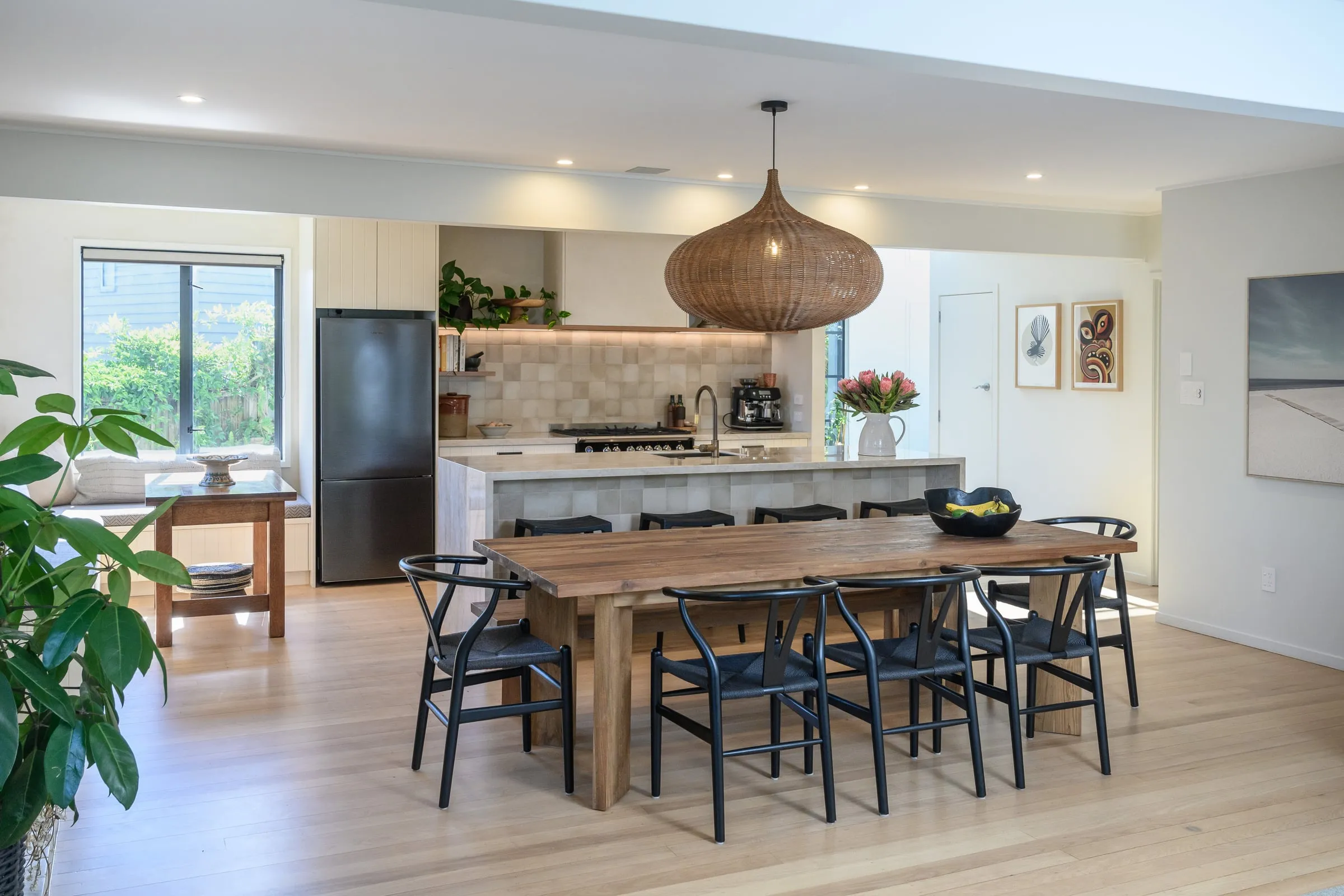 Open-plan kitchen and dining with a woven rattan pendant over an Oak table