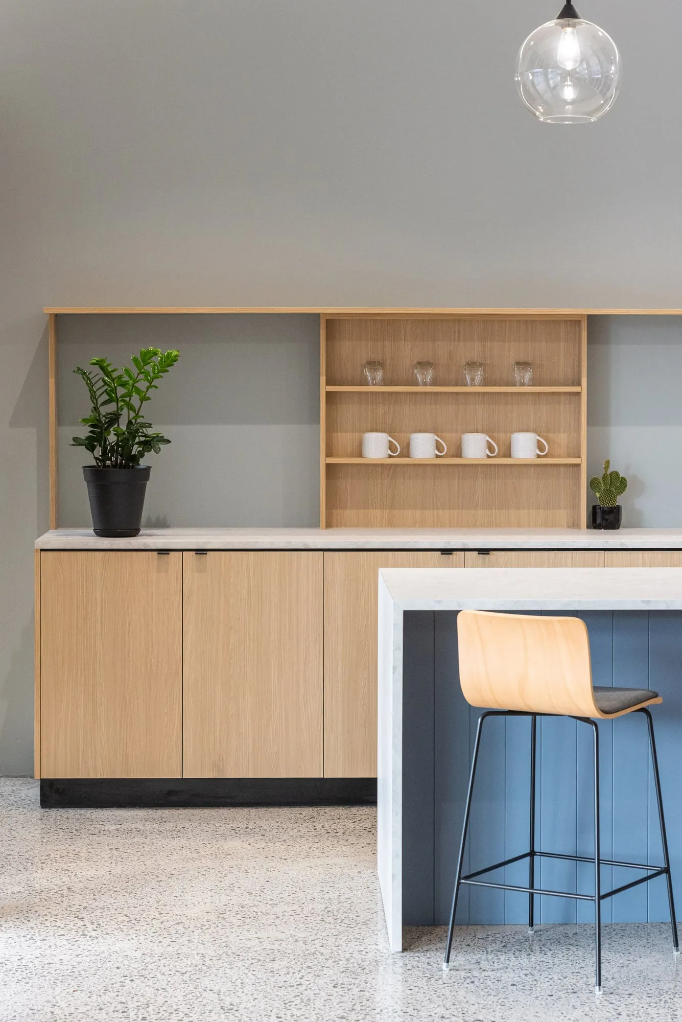 Kitchenette elevation with Oak cabinetry, open shelving and slate-blue V-groove island