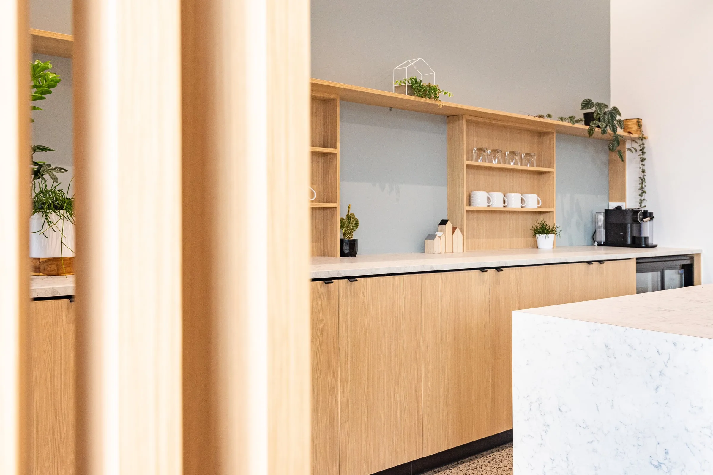 Kitchenette joinery seen through blurred pale Ash battens
