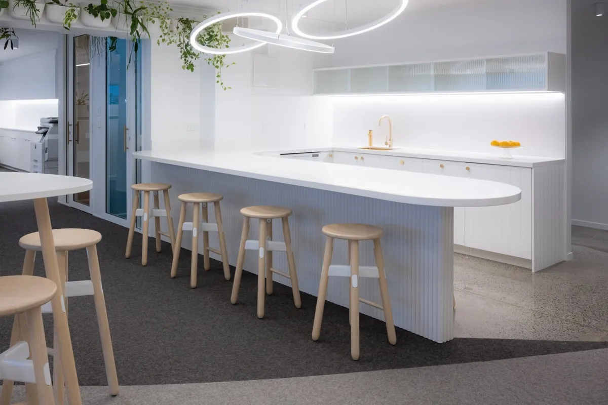 Bar-height island with brass gooseneck tap and reeded-glass overhead cabinets