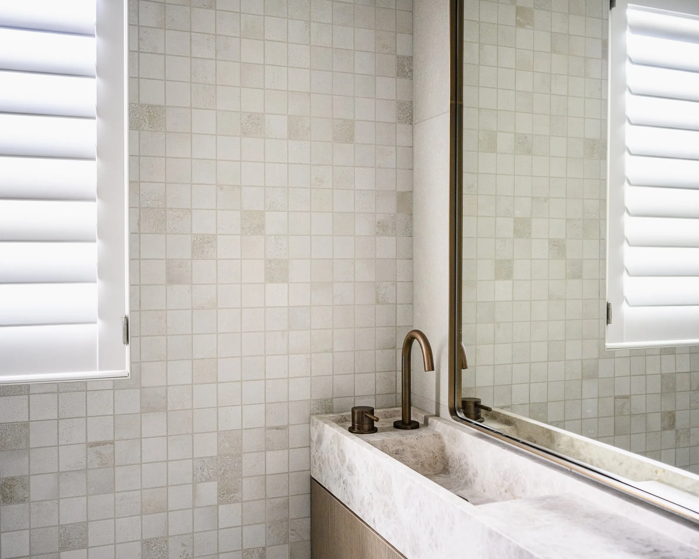 Stone basin edge, aged brass tapware and Limestone mosaic detail