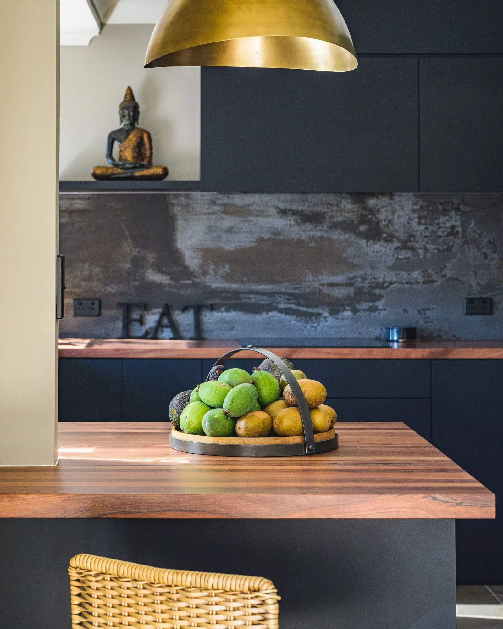 Timber bar top with fruit tray beneath a brass pendant rim