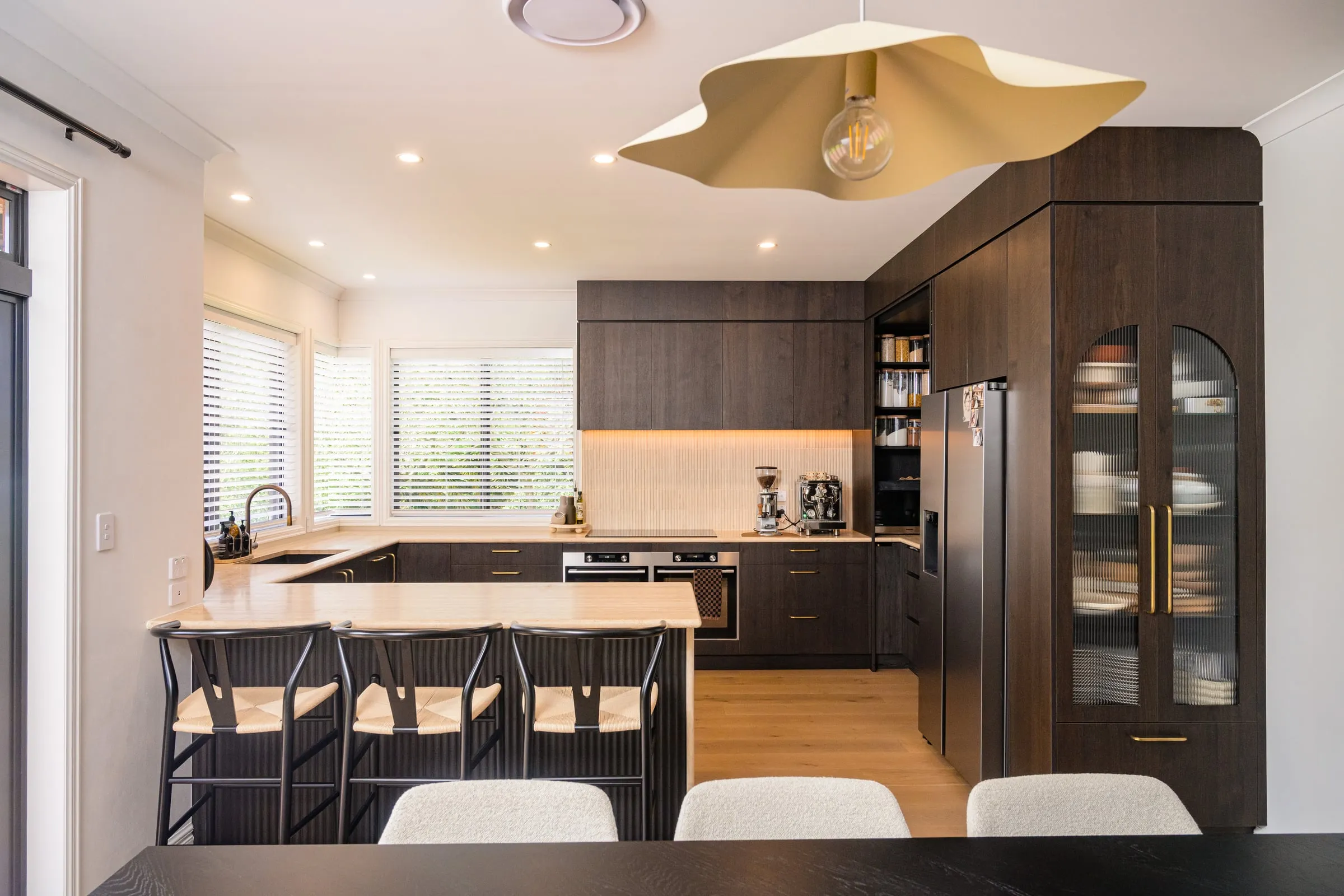 Straight-on kitchen elevation with sculptural brass pendant above