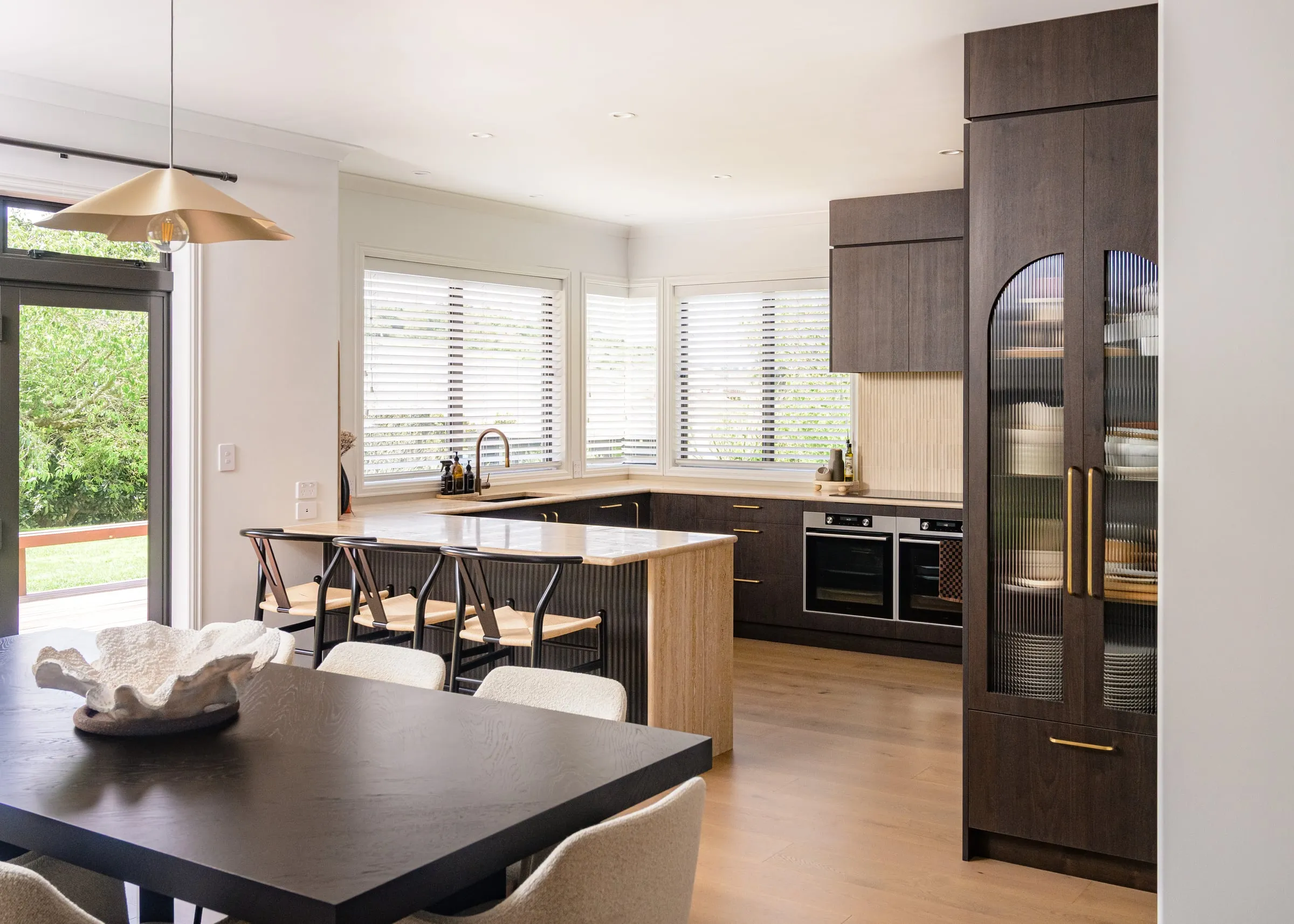 Walnut and Travertine kitchen seen wide from the dining zone